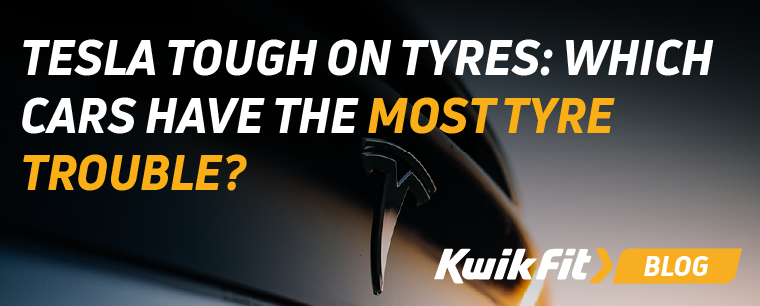 A close up of the tesla badge on the front of a car